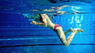 Eine Frau schwimmt in einem Freibad bei Mainz (Archivbild)