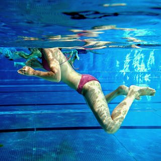 Eine Frau schwimmt in einem Freibad bei Mainz (Archivbild)