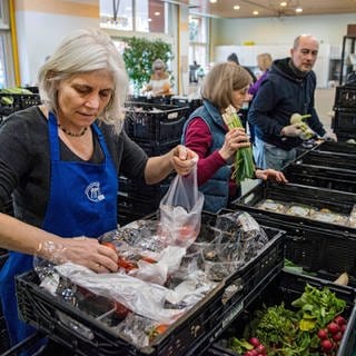 Ehrenamtliche Helferinnen und Helfer der Tafel sortieren Lebensmittel für Bedürftige