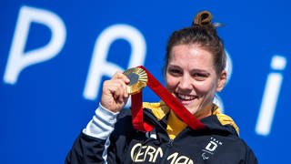 Maike Hausberger aus Trier feiert ihre Goldmedaille im Einzelzeitfahren.  