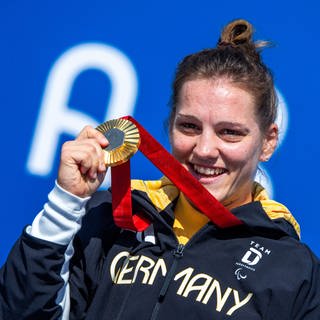 Maike Hausberger aus Trier feiert ihre Goldmedaille im Einzelzeitfahren.  