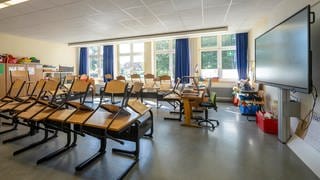 Ein leeres Klassenzimmer mit hoch gestellten Stühlen (Symbolbild). Mehrere Schulen in RLP haben Bombendrohungen erhalten. Die Polizei gab jedoch Entwarnung.