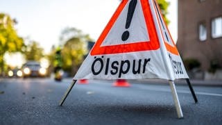 Schild mit Aufschrift Ölspur - Schwerer Unfall wegen Ölspur, Polizei sucht Zeugen