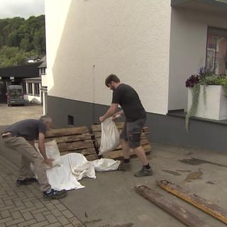 Zwei Personen bauen eine Flutbarriere