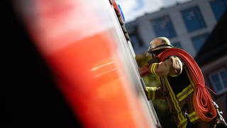 Einsatzkraft der Feuerwehr mit Schlauch. Im Westerwald gab es auch einen Einsatz. Ein Retter wurde bei dem Brand einer Scheune verletzt.