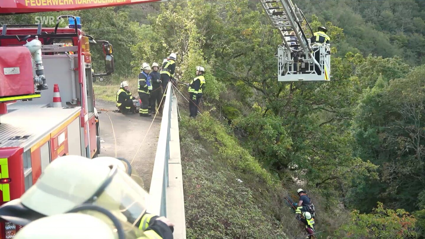 Feuerwehr und Polizei bergen eine Leiche an einem Hang