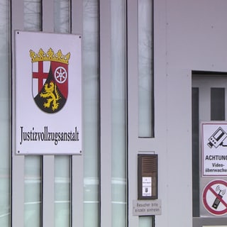 Der Eingang einer Justizvollzugsanstalt in RLP - die hochgesichert Tür öffnet sich. Am Samstag können Interessierte einen Blick hinter die Kulissen in der JVA Frankenthal werfen. 