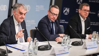 Herbert Reul (l, CDU), Innenminister von Nordrhein-Westfalen, Benjamin Limbach (M, Grüne), Justizminister Markus Hartmann , Leiter der Ansprechstelle Cybercrime, sprechen auf einer Pressekonferenz zu Kindesmissbrauch im Darknet.