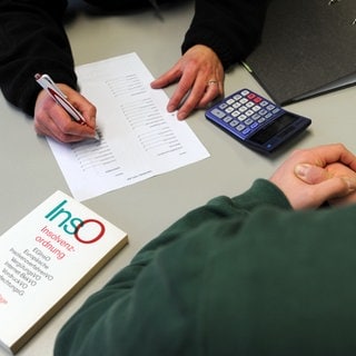 Ein Mann sitzt in einem Beratungsgespräch bei einer Schuldner- und Insolvenzberatungsstelle.