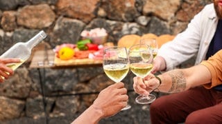 Ein Prost mit zwei Gläsern Weiswein: Die Weinernte 2024 in Deutschland ist in diesem Jahr ungewöhnlich klein ausgefallen. Das Endprodukt soll aber fein schmecken.