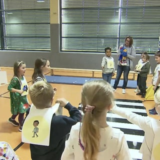 Kinder lernen Straßenverkehr in einer Turnhalle