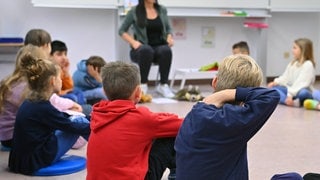 Kinder werden im Gesprächskreis unterrichtet. Für Erstklässler ist die Betreuung ab dem Schuljahr 2026 sogar ganztägig ein Pflichtangebot.