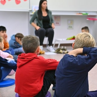 Kinder werden im Gesprächskreis unterrichtet. Für Erstklässler ist die Betreuung ab dem Schuljahr 2026 sogar ganztägig ein Pflichtangebot.