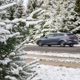 Ein Auto fährt durch die Schneelandschaft rund um den Erbeskopf im Hunsrück. Die Bäume sind weiß, die Straße aber schneefrei. In den höheren Lagen von Rheinland-Pfalz hat es geschneit. Neuer Schnee und Straßenglätte werden erwartet.