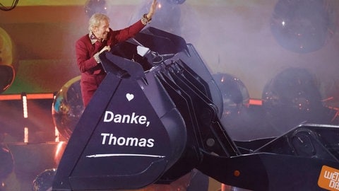 25.11.2023: Thomas Gottschalk wird am Ende der ZDF-Show "Wetten, dass..?" in einer Baggerschaufel über die Bühne gefahren.