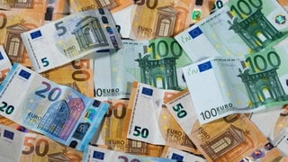 Ein Stapel verschiedener Euroscheine in bunten Farben, der die finanzielle Verschwendung und die hohen Ausgaben in kommunalen Unternehmen symbolisiert, die vom Landesrechnungshof kritisiert werden.