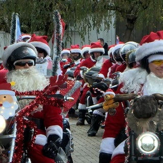 25 Weihnachtsmänner oder Santas sind mit ihren Harley-Davidson-Motorrädern unterwegs und sammeln Spenden.