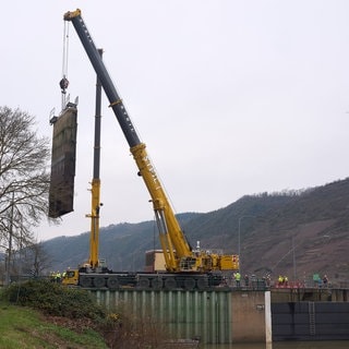 Kran hebt ein beschädigtes Schleusentor aus der Schleuse Müden. 