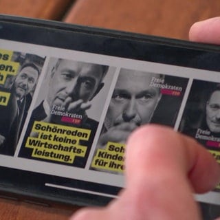 Plakate der FDP auf einem Smartphone