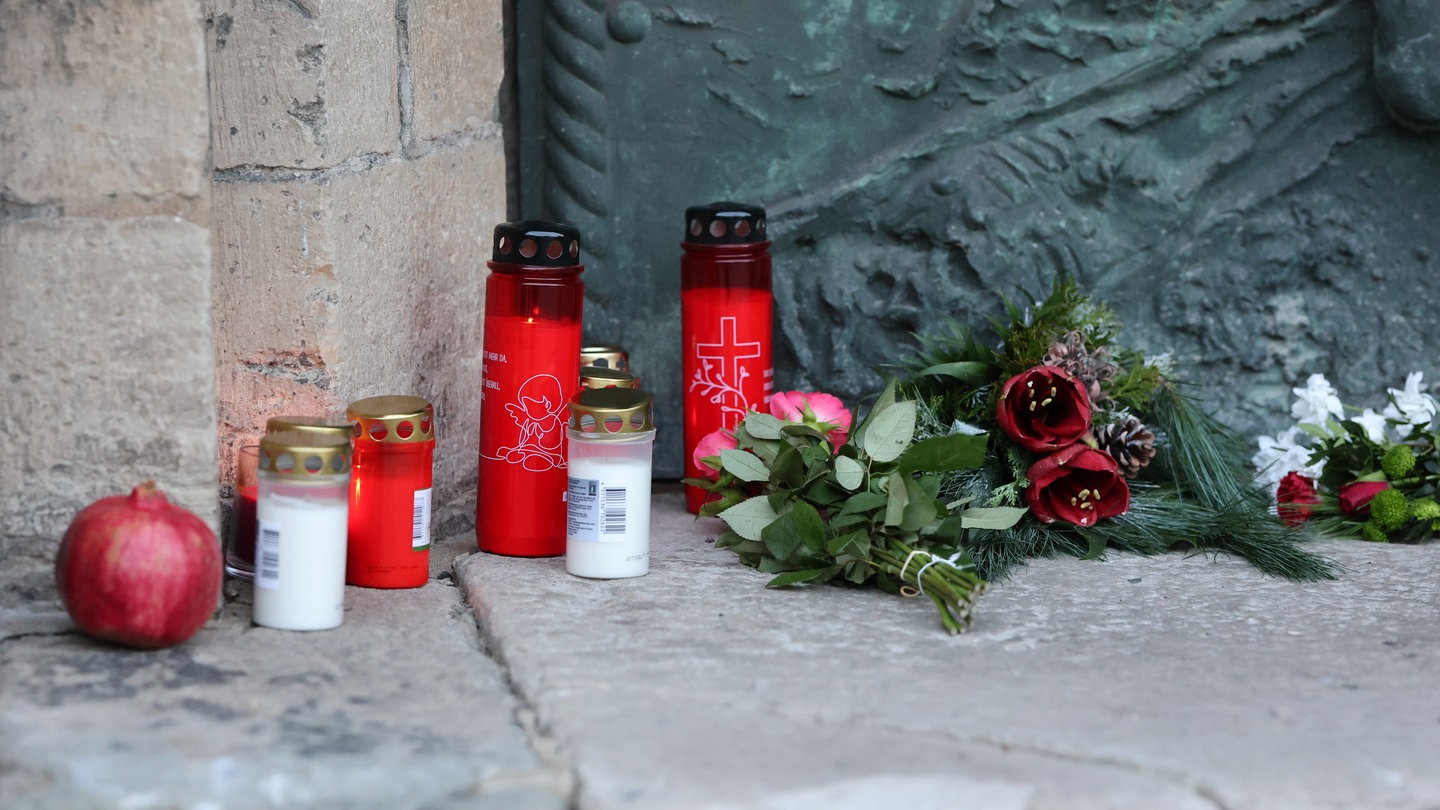 Kerzen und Blumen liegen vor der Johanneskirche in Magdeburg. Sie wurde nach dem Attentat am Freitagabend, als ein Autofahrer in eine Menschengruppe raste und fünf Menschen starben, zum offiziellen Trauerort. Auch Rheinland-Pfalz trauert mit den Opfern.