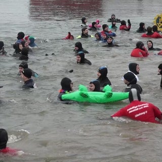 Personen schwimmen im Rhein