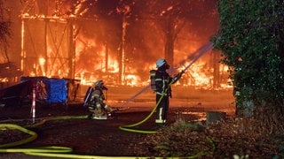 Einsatzkräfte der Feuerwehr bekämpfen in der Silvesternacht den Brand einer Lagerhalle in Engers, einem Stadtteil von Neuwied.