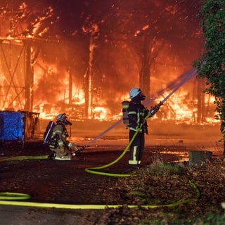 Einsatzkräfte der Feuerwehr bekämpfen in der Silvesternacht den Brand einer Lagerhalle in Engers, einem Stadtteil von Neuwied.