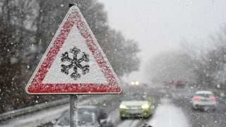 Ein Verkehrschild, das mit Schnee und Eis bedeckt ist, warnt vor Gefahr von Schnee- oder Eisglätte auf der Fahrbahn. Der Deutsche Wetterdienst warnt am Wochenende vor Blitzeis durch gefrierenden Regen. 