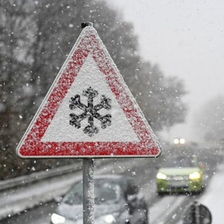 Ein Verkehrschild, das mit Schnee und Eis bedeckt ist, warnt vor Gefahr von Schnee- oder Eisglätte auf der Fahrbahn. Der Deutsche Wetterdienst warnt am Wochenende vor Blitzeis durch gefrierenden Regen. 