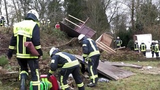 Feuerwehrmänner bei einer vom Sturm verwüsteten Bushaltestelle