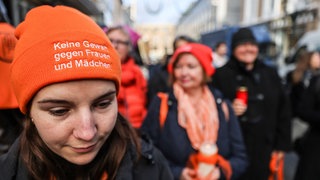 Eine Frau trägt bei einer Mahnwache eine Mütze mit der Aufschrift "Keine Gewalt gegen Frauen und Mädchen" (Archivbild).