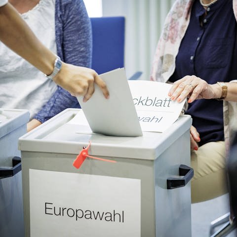 Ein Wähler wirft seinen Stimmzettel für die Europawahl 2024 in eine Wahlurne