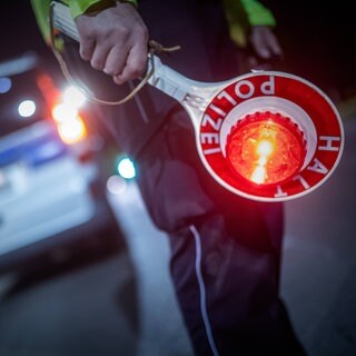 Ein Polizist mit einer Keller in der Hand.