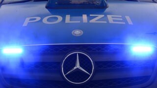 Die Aufschrift Polizei steht auf einem Polizeiwagen.