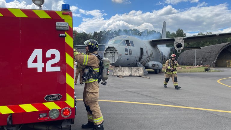 Rettungskräfte laufen zu verunglücktem Flugzeug