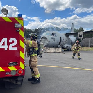 Rettungskräfte laufen zu verunglücktem Flugzeug