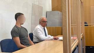 Ein junger Mann sitzt im Gericht im Amtsgericht in Rockenhausen. Er ist wegen Brandstiftung in einer Schreinerei in Bolanden angeklagt.