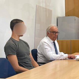Ein junger Mann sitzt im Gericht im Amtsgericht in Rockenhausen. Er ist wegen Brandstiftung in einer Schreinerei in Bolanden angeklagt.