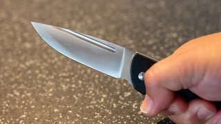 Eine Hand hält ein Messer.