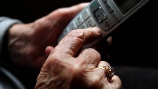 Frau hält Telefon in der Hand - Schockanrufe angeblich aus Krankenhaus Pirmasens
