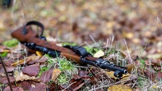 Das Gewehr eines Jägers liegt im Wald auf dem Boden