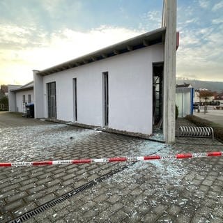 Glasscherben und Absperrband der Polizei - In Fischbach bei Dahn gab es eine Explosion, offenbar wurde ein Geldautomat gesprengt