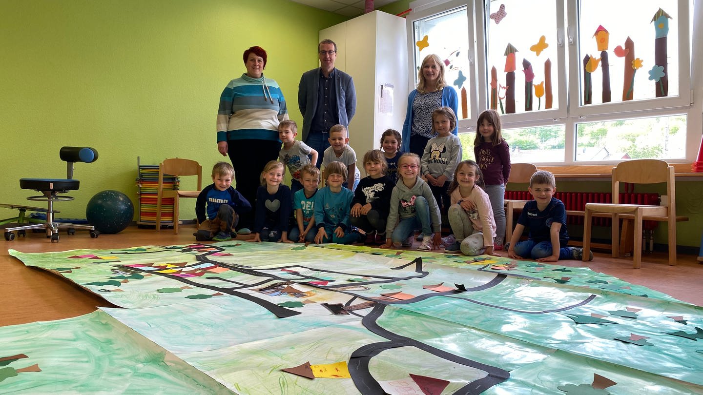 Die Kinder der KITA Waldwichtel in Mölschbach, einem Stadtteil von Kaiserslautern, haben ein großes Plakat von Mölschbach gestaltet.