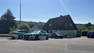 Die Polizei bewacht in Rammelsbach im Kreis Kusel ein Wohnhaus.