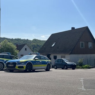 Die Polizei bewacht in Rammelsbach im Kreis Kusel ein Wohnhaus.