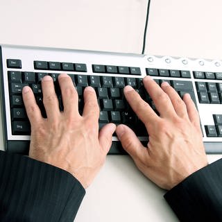 Mann aus Kaiserslautern um mehrere Zehntausend Euro betrogen - Hände auf Computertastatur