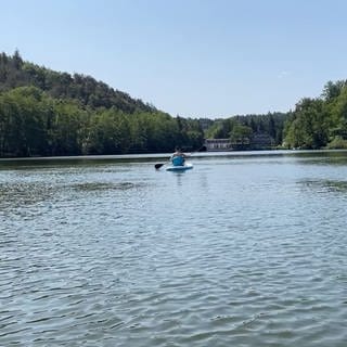 Frau fährt mit Stand-Up-Paddle auf Gelterswoog