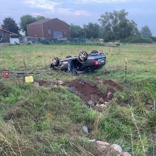 Auto liegt auf dem Dach im Gras nahe dem Mehlbach zwischen Katzweiler und Hirschhorn.