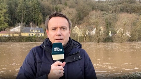 SWR-Reporter Sebastian Stollhof beim Hochwasser am Glan in Odenbach. 