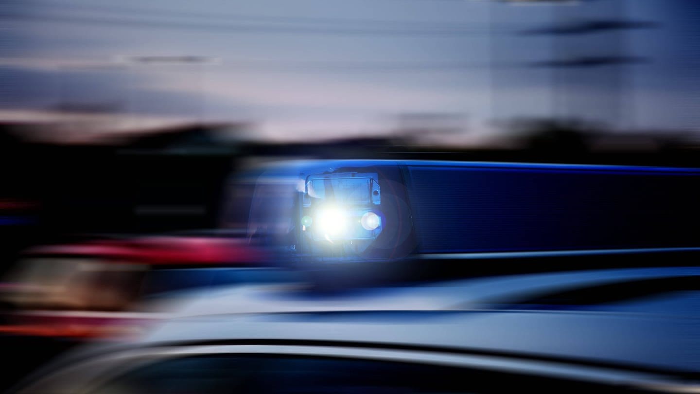 Verwackeltes Blaulicht auf einem schnellfahrenden Polizeifahrzeug im Einsatz.